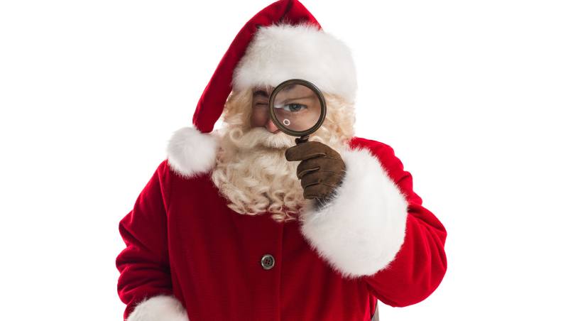 Papa Noel con lupa en el ojo, simbolizando consejos para cuidar la salud visual en Navidad.