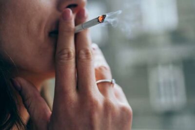 Mujer fumando un cigarrillo, representando el impacto del tabaco en la salud femenina en España.