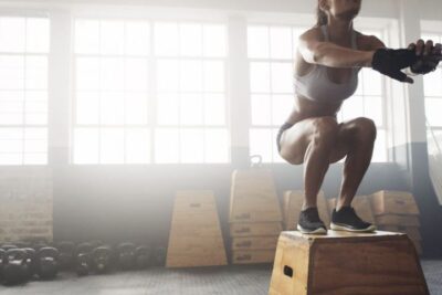 Persona realizando un entrenamiento con cajón en un gimnasio, representando un ejercicio eficaz para quemar calorías.